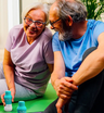 Older couple smiling together on a yoga mat with The Plug liver support drink bottles beside them