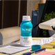 Open bottle of The Plug liver health drink on a desk with notes and a pen