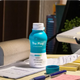 Open bottle of The Plug liver health drink on a desk with notes and a pen
