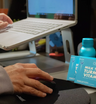 The Plug liver support drink bottle and Milk Thistle Turmeric Vitamin B pill boxes on a desk next to a laptop