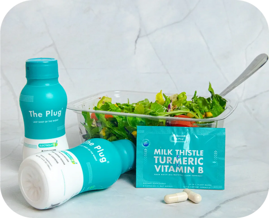 The Plug liver support drink bottle, Milk Thistle Turmeric Vitamin B pills, and a fresh salad